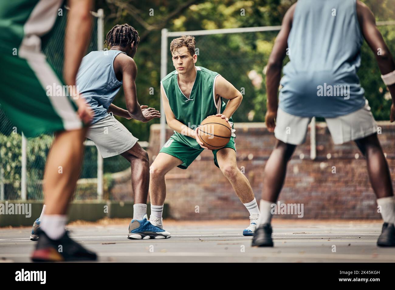 Pallacanestro, sport di squadra e competizione per gli atleti e i giocatori di sesso maschile in allenamento o partita professionale in un campo di fitness all'aperto. Diversità Foto Stock