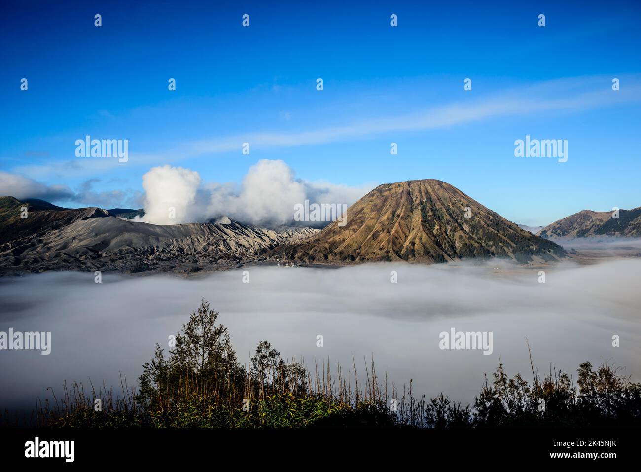 Monte bromo vulcano, un vulcano somma e parte della catena montuosa Tengger, il cono che si erge sopra la bassa nuvola nel paesaggio. Foto Stock