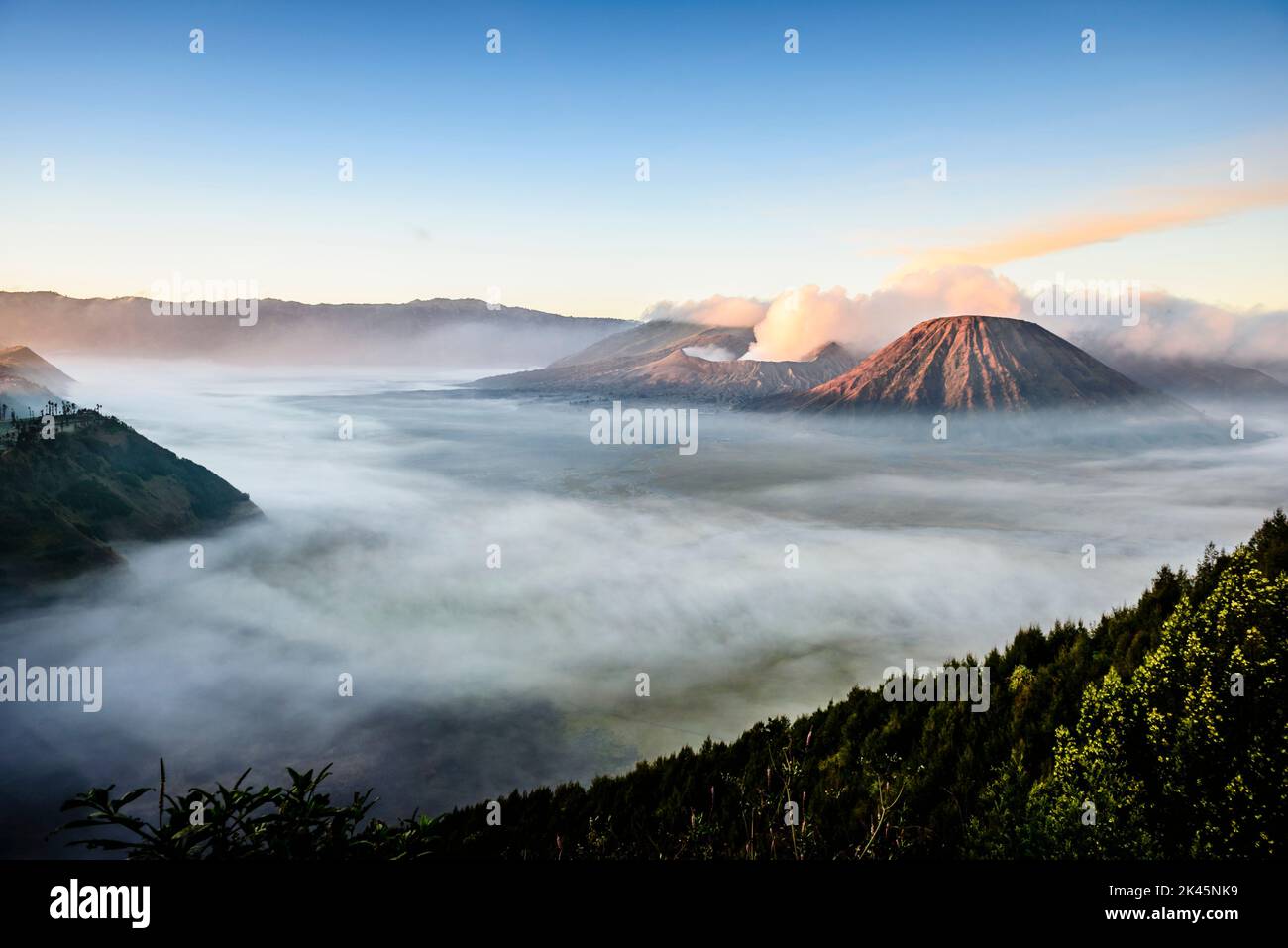 Monte bromo vulcano, un vulcano somma e parte della catena montuosa Tengger, il cono che si erge sopra la nebbia nel paesaggio. Foto Stock