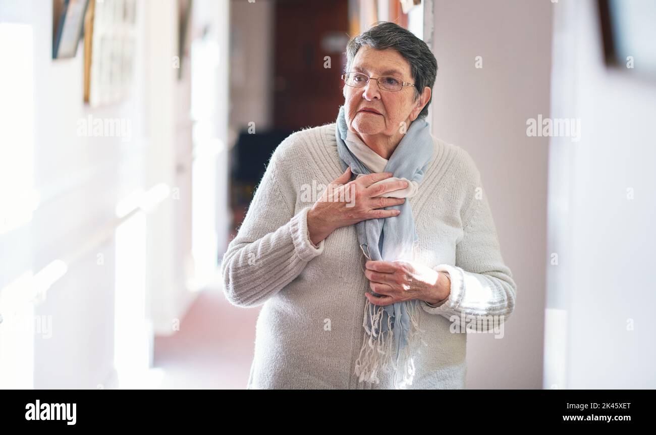 Pensione, distorsione di velocità e stile di vita con una donna anziana con i capelli grigi che osservano scioccati o sorpresi nella sua casa. Shock, sorpresa e stupore con un anziano Foto Stock