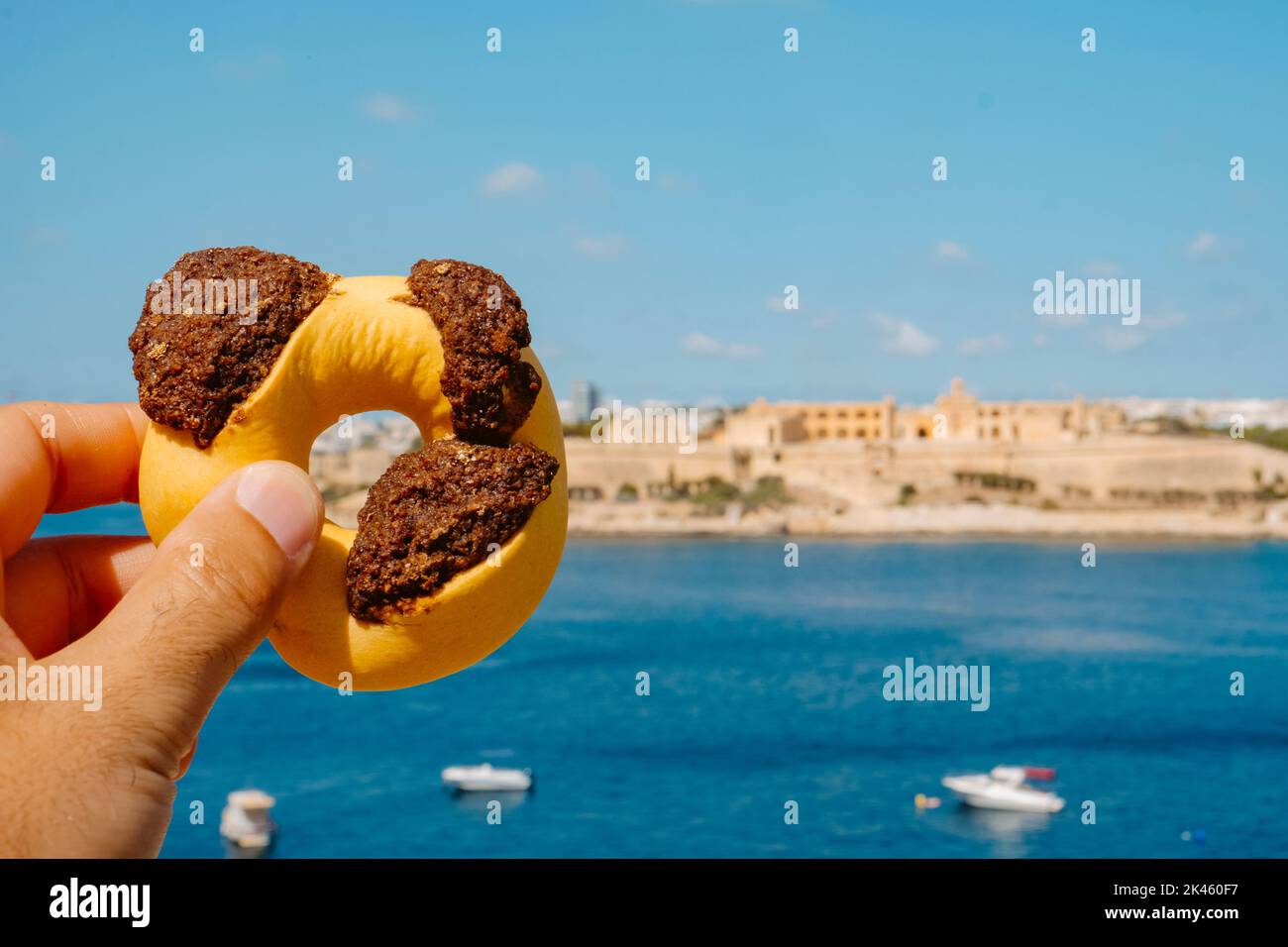 Primo piano di un uomo che detiene un gasel maltese qaghaq tal-ghasel, conosciuto anche come anello di miele in inglese, a la Valletta, Malta Foto Stock