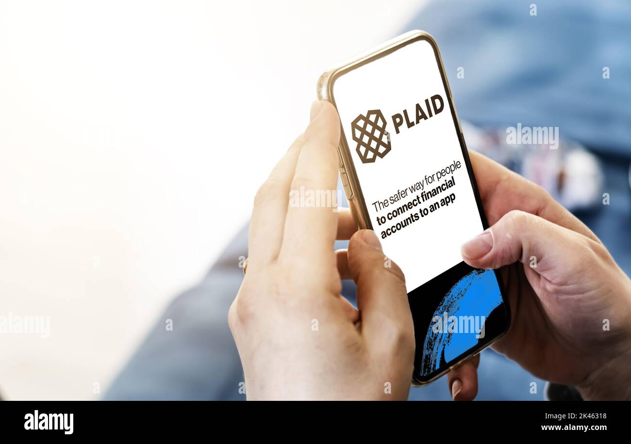 San Francisco, USA, giugno 2022: Mani femminili che tengono un telefono con la homepage di Plaid sullo schermo. Logo a plaid sfocato su sfondo blu. Plaid è un financi Foto Stock