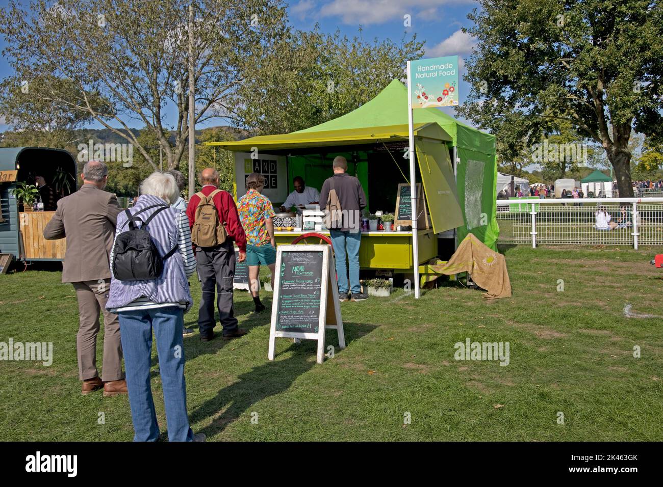 Persone in coda presso la stalla di cibo naturale Three Counties Showground, Great Malvern, UK Foto Stock