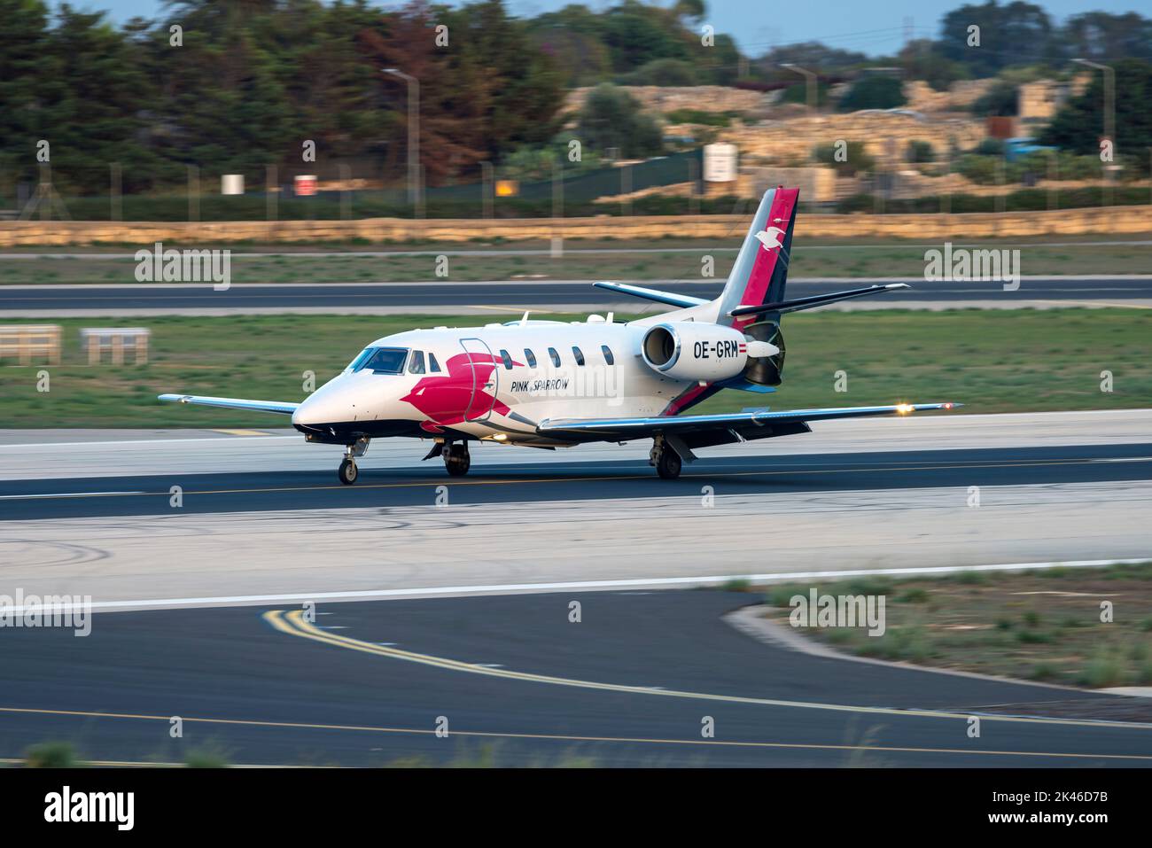 Pink Sparrow Cessna 560XLS Citation Excel + (Reg: OE-GRM) atterrando come il sole sta tramontando. Foto Stock