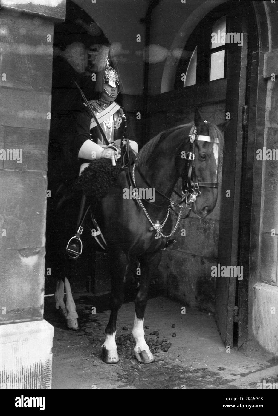 1958, storico, un King's Life Guard a cavallo, in servizio di sentinella alle Horse Guards, ingresso ufficiale al Palazzo di Whitehall, Westminster, Londra, Inghilterra, Regno Unito. Il guardiano montato indossa uniforme completa, tunica e copricapo cerimoniale noto come elmetto Albert. Foto Stock