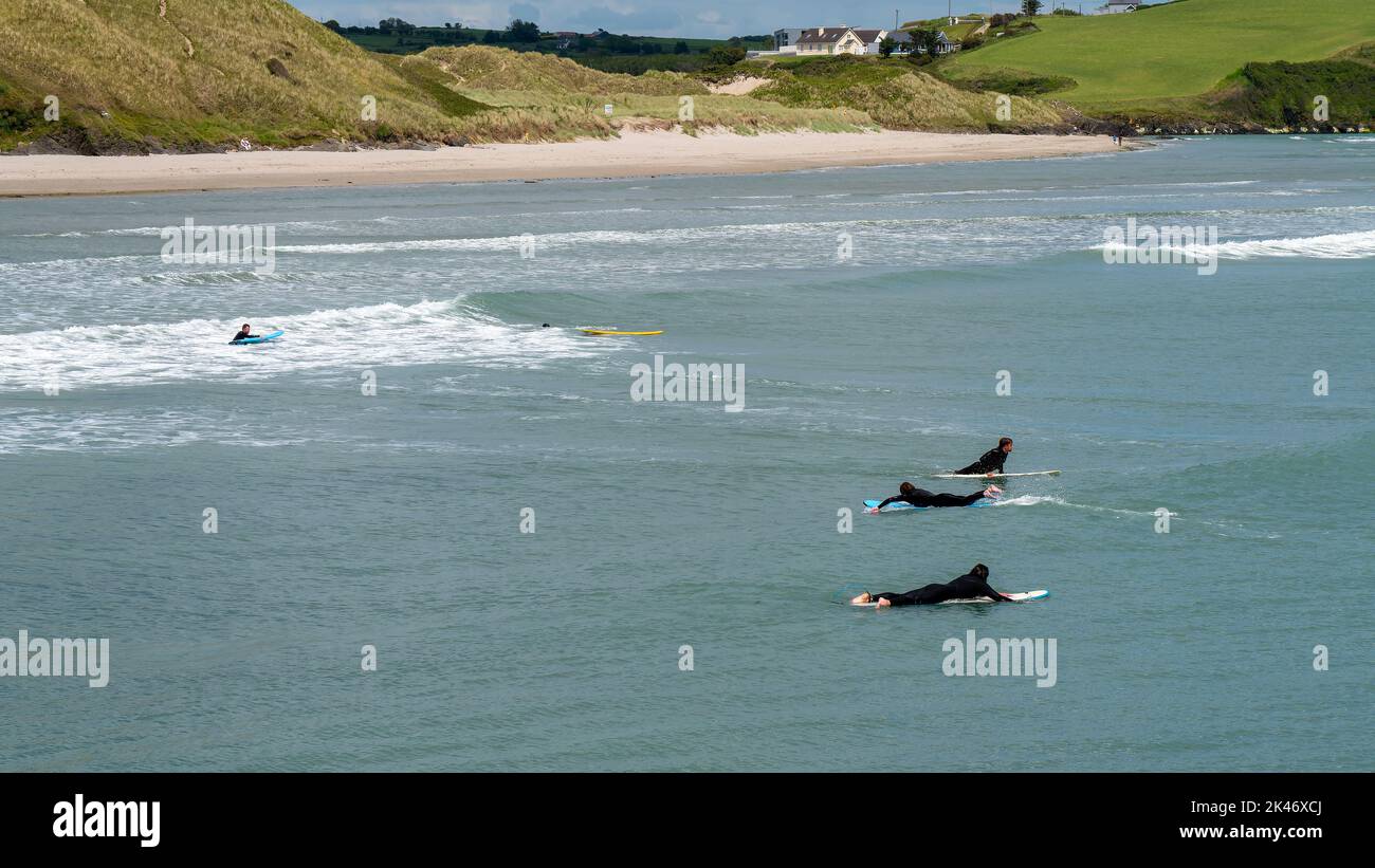 West Cork, Irlanda, 12 giugno 2022. I surfisti cavalcano le onde a Clonakilty in una giornata estiva. Sport acquatici in Irlanda, paesaggio. La costa irlandese dell'AT Foto Stock