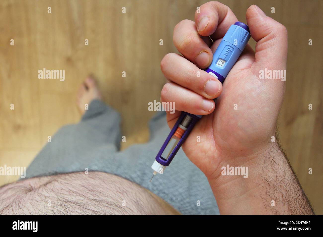 Uomo in sovrappeso che applica iniezione di medicinale per il diabete (siringa) nello stomaco, nella pancia Foto Stock