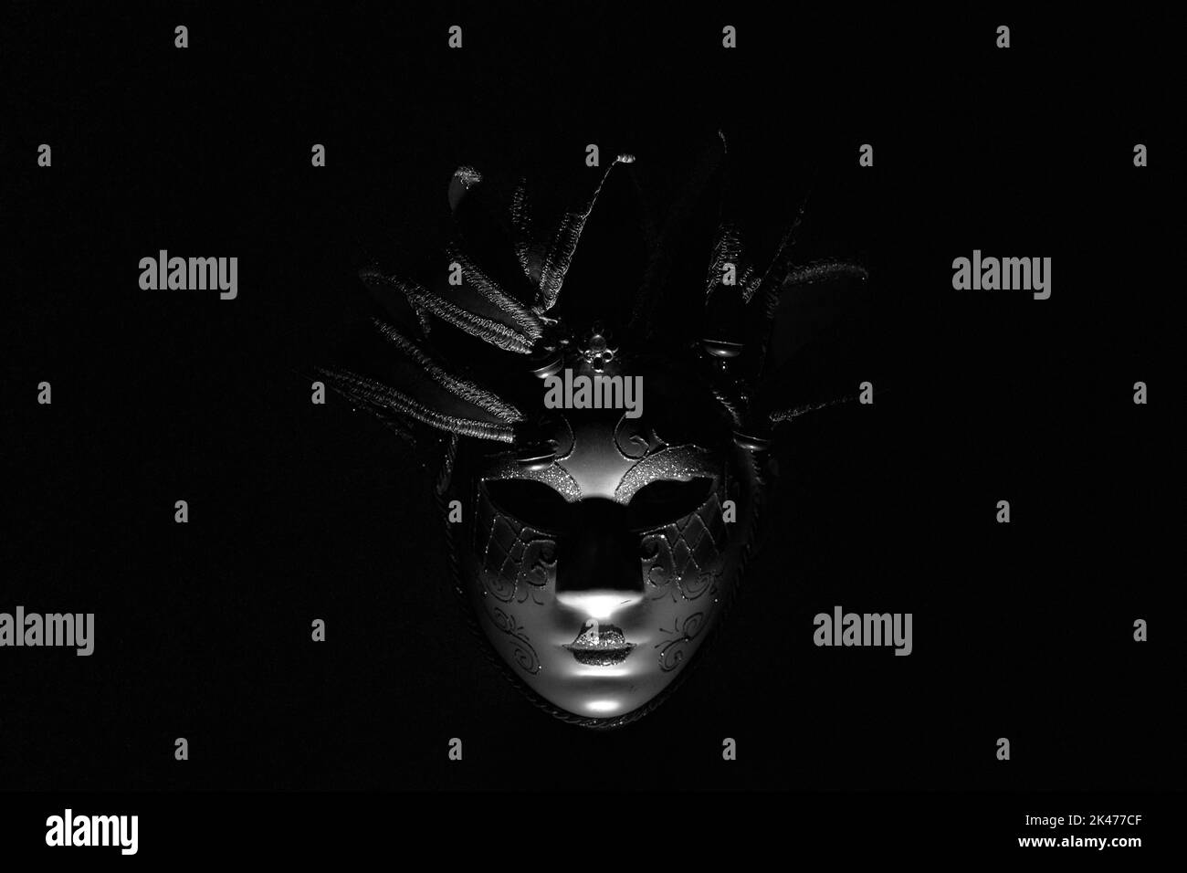 Il volto di una ragazza in una maschera di carnevale veneziana al buio, una mascherata e un attore in una maschera, teatro Foto Stock
