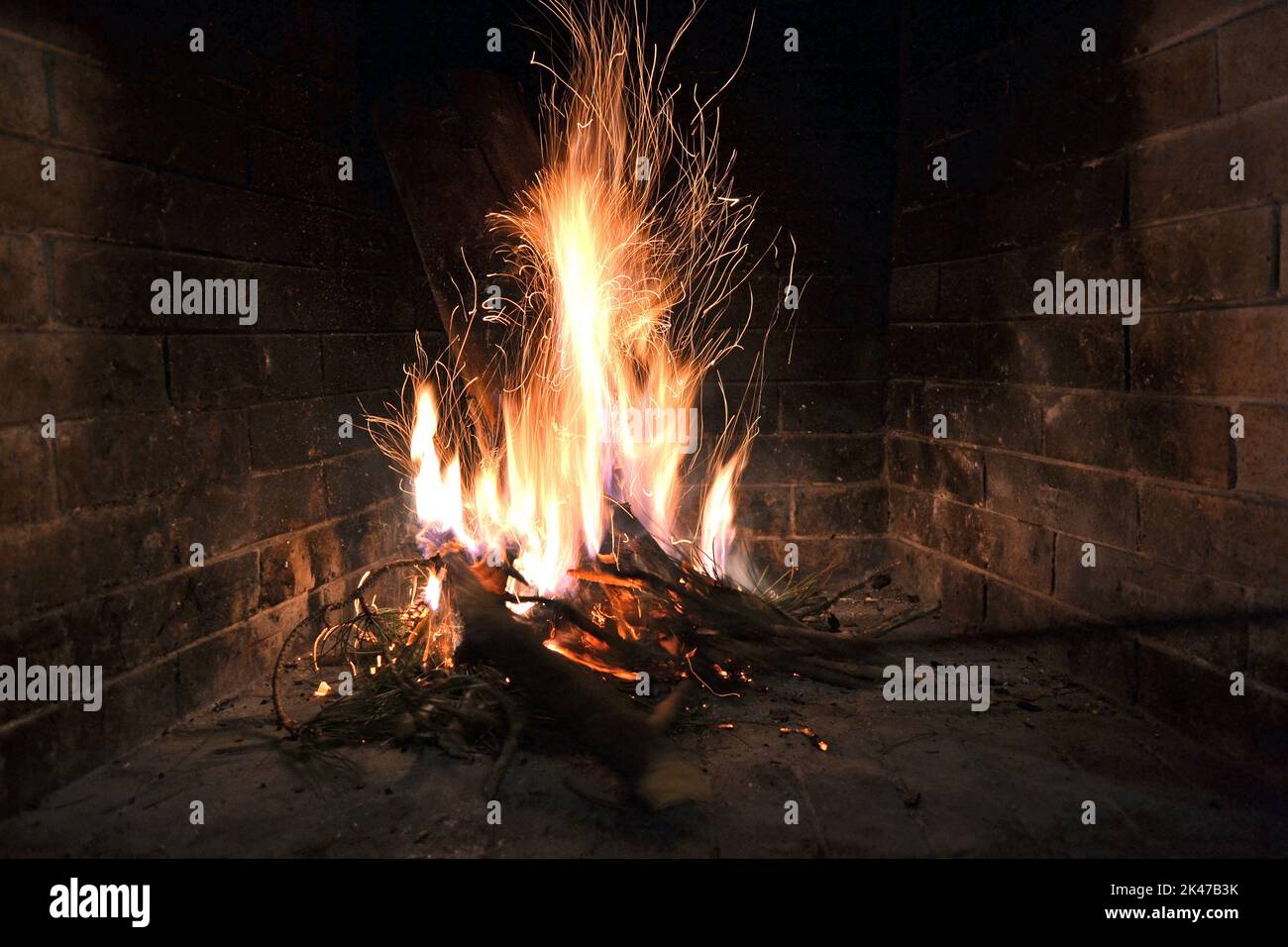 Fuoco scintillante all'interno di un caminetto. Foto Stock