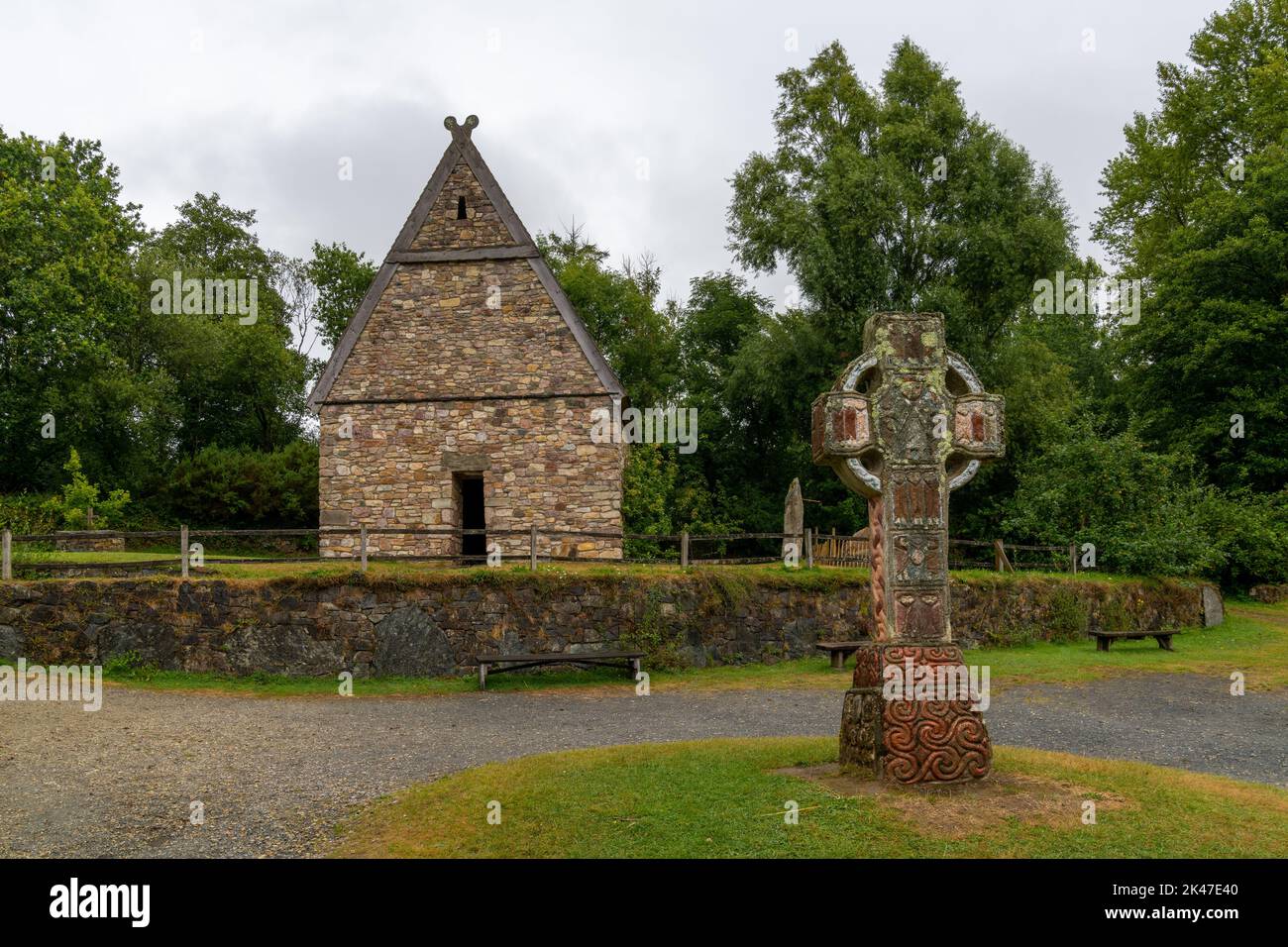 Wexford, Irlanda - 18 agosto, 2022: Vista di un monastero cristiano ricostruito in anticipo nel Parco del Patrimonio Nazionale Irlandese con una grande croce celtica i Foto Stock