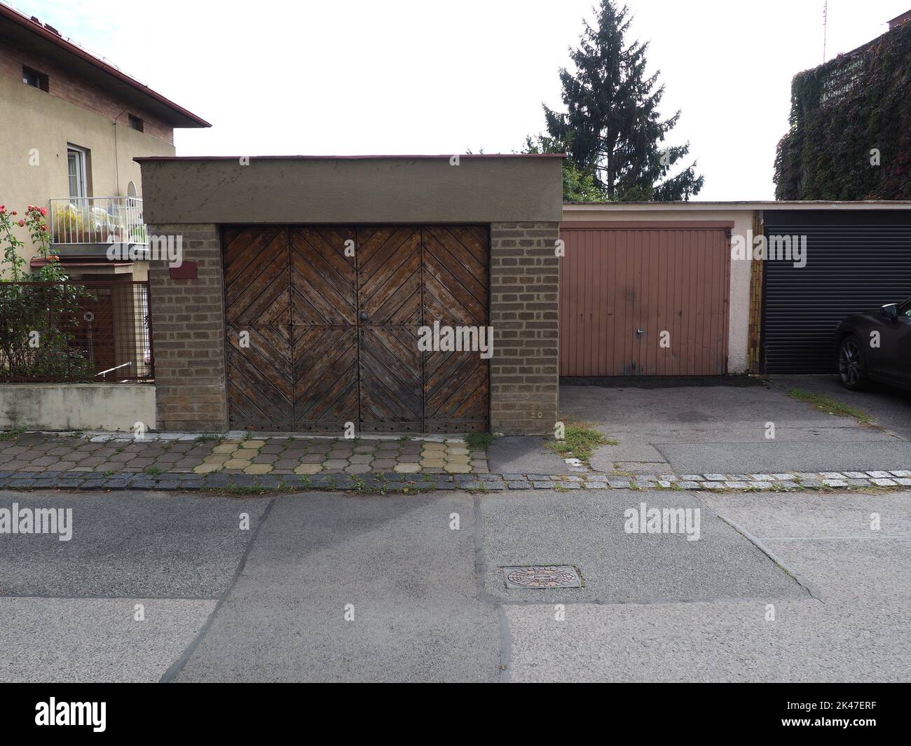 Porte di garage vecchie, sporche, in legno retrò e in metallo in una moderna area urbana Foto Stock