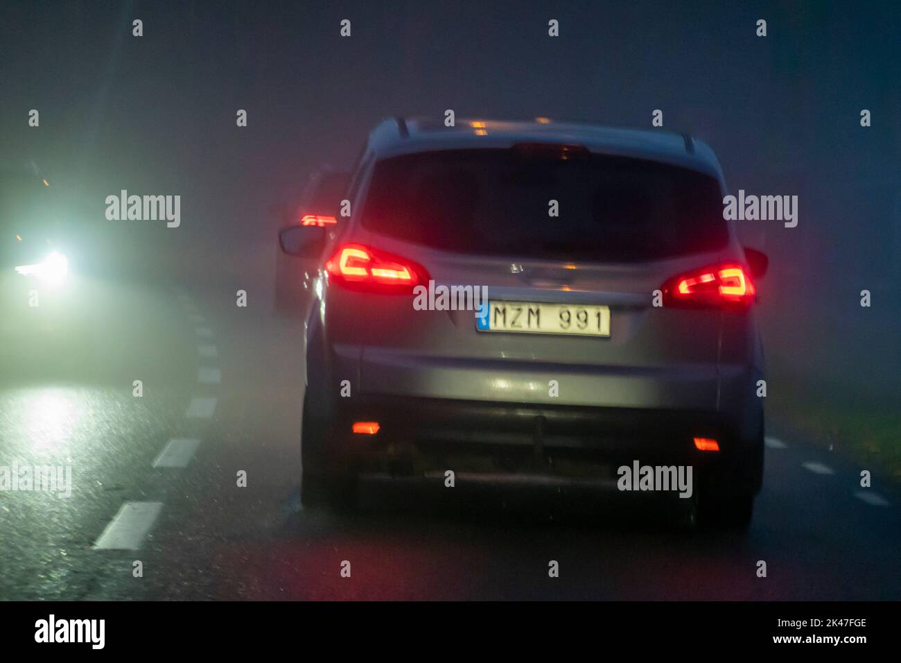 Auto che guida nella nebbia di notte Foto Stock