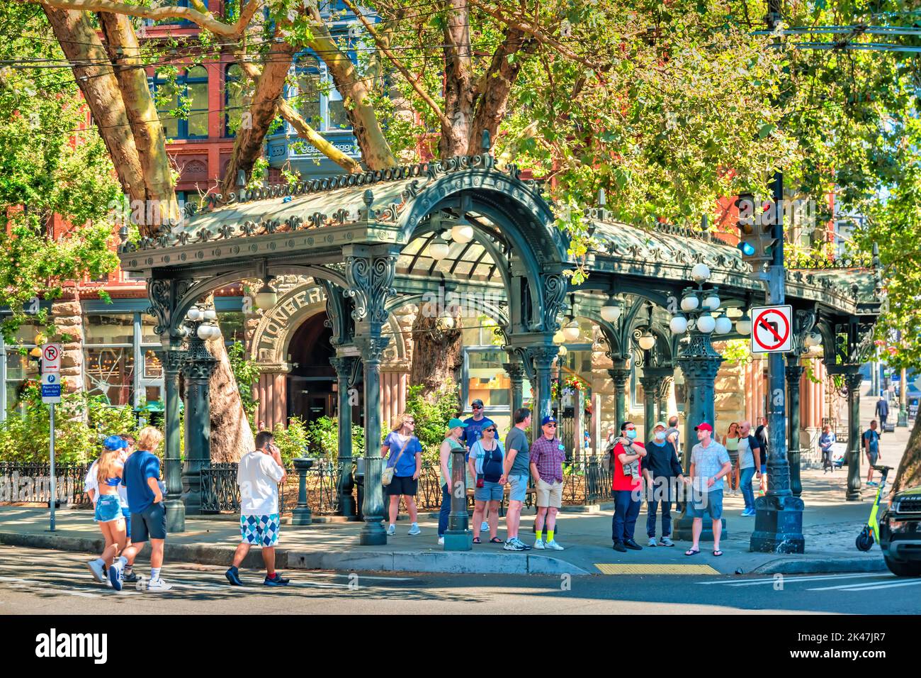 I Pedistri aspettano accanto alla storica Pioneer Square Pergola nel centro di Seattle, Washington USA Foto Stock