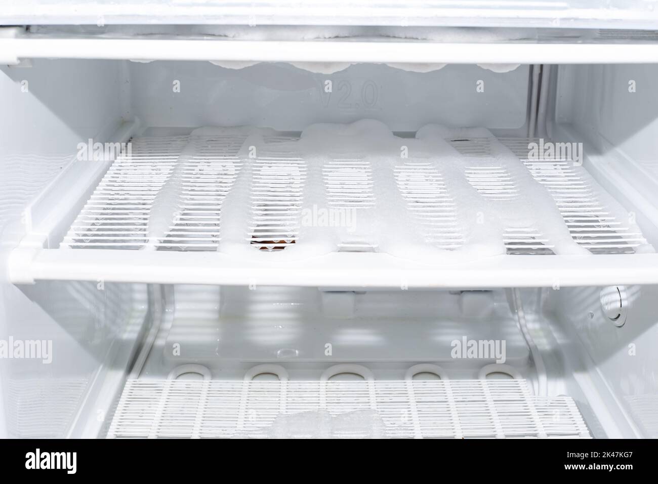 Congelatore con ripiani coperti di ghiaccio. Sbrinamento e cura del congelatore. Foto Stock