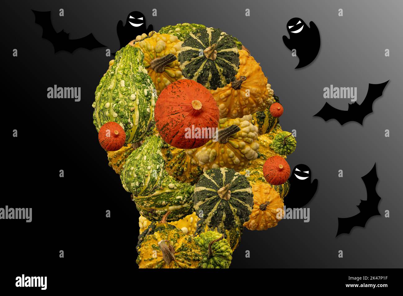 Testa di una persona fatta di zucche decorative e halloween con fantasmi volanti e pipistrelli intorno. Simboli di Halloween. Oscurità circostante. Foto Stock