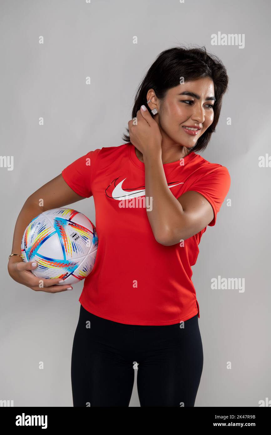 Giovane giocatore di calcio con FIFA Qatar Match palla al Rihla su sfondo isolato Foto Stock