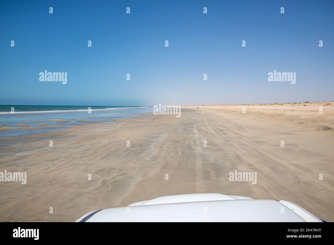 Guida con un servizio di prelievo 4x4 su una spiaggia sabbiosa durante la bassa marea, l'Oman meridionale Foto Stock