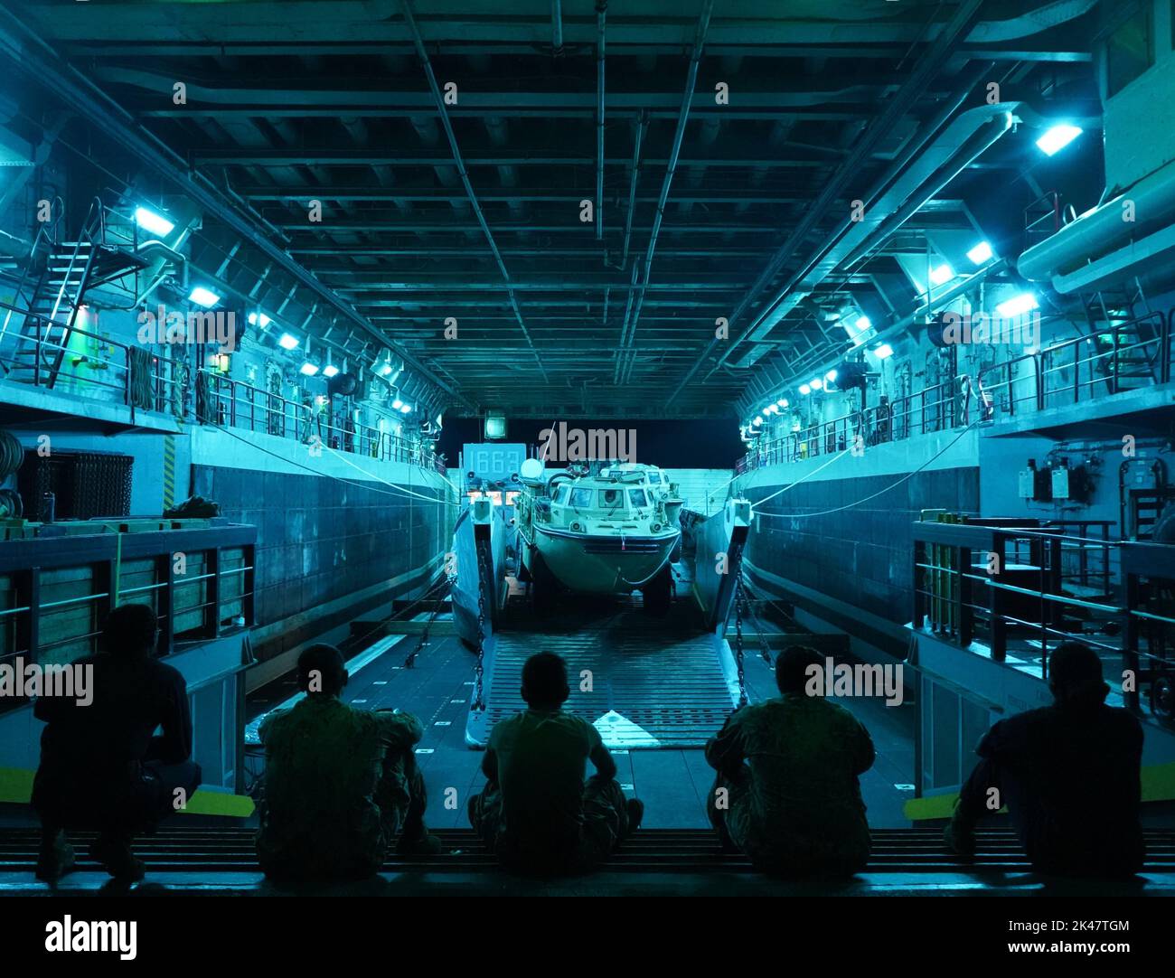 Tre Marines della Special Purpose Marine Air-Ground Task Force UNITAS LXIII e due marinai della nave portuale di trasporto anfibio USS Mesa Verde (LPD 19), si socializzano nel ponte dei pozzi della nave di classe San Antonio, mentre si affacciano sull'imbarcazione di sbarco caricata, Utilità 1663 la sera prima del culminante raid anfibio di UNITAS LXIII, al largo della costa del Brasile, 15 settembre 2022. Il raid anfibio è l'evoluzione finale congiunta e combinata della formazione DI UNITAS LXIII, dove i marinai e il personale della marina di 19 paesi diversi combinano le loro risorse collettive per condurre una nave-a-shor Foto Stock