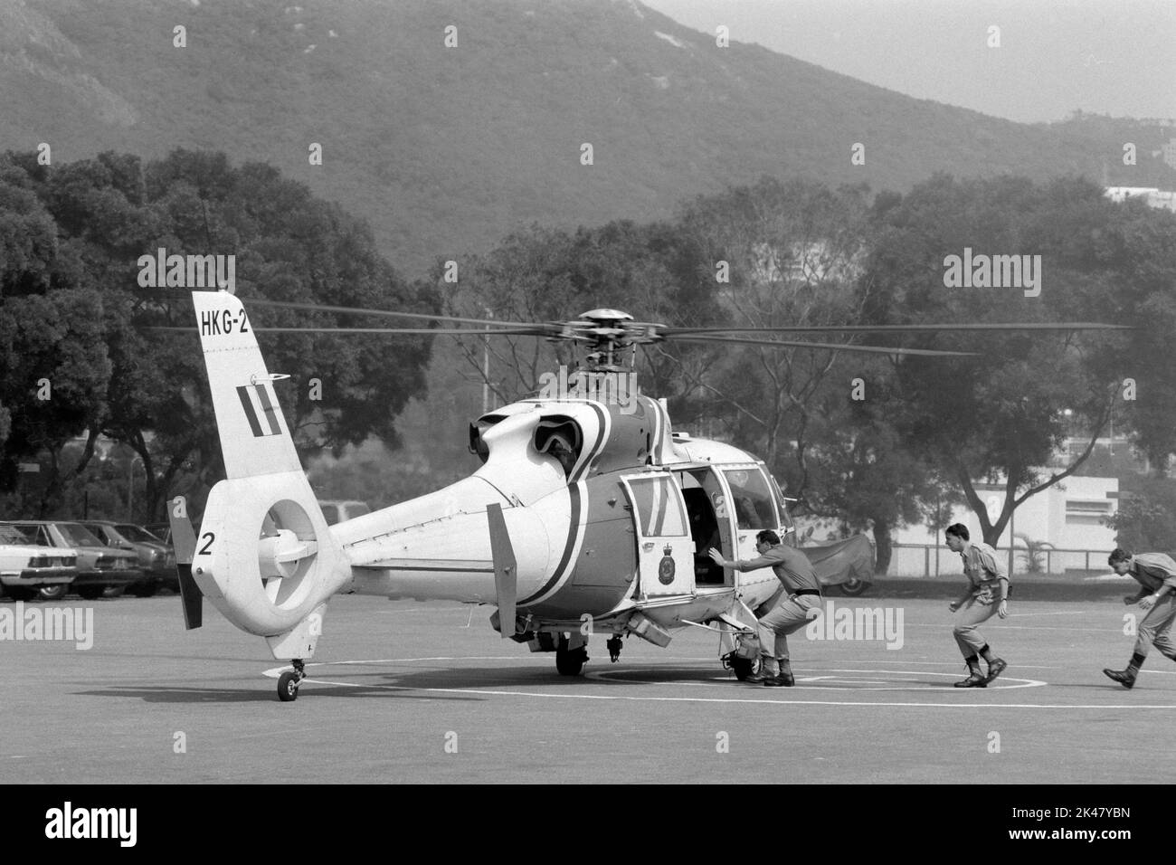I tirocinanti salgono a bordo di un elicottero Aerospatiale Dauphin, gestito da Hong Kong's Government Flying Services, pronto per il decollo presso la Police Training School, Hong Kong 1984 Foto Stock