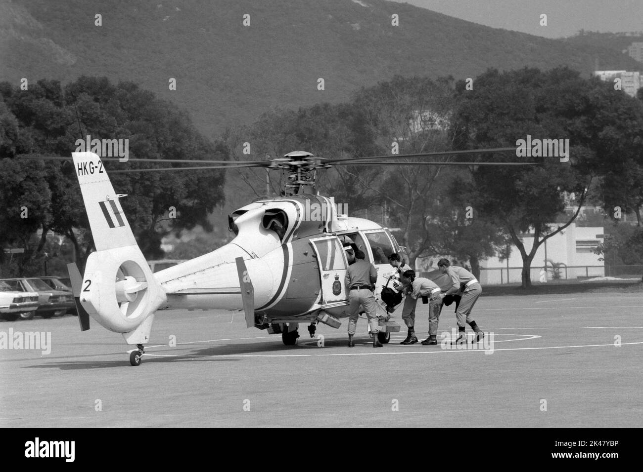 I tirocinanti salgono a bordo di un elicottero Aerospatiale Dauphin, gestito da Hong Kong's Government Flying Services, pronto per il decollo presso la Police Training School, Hong Kong 1984 Foto Stock