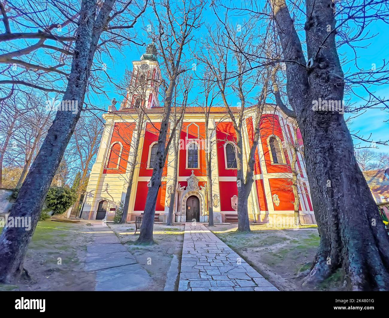 Il vecchio parco con alberi alti e la storica Cattedrale di Belgrado, Szentendre, Ungheria Foto Stock