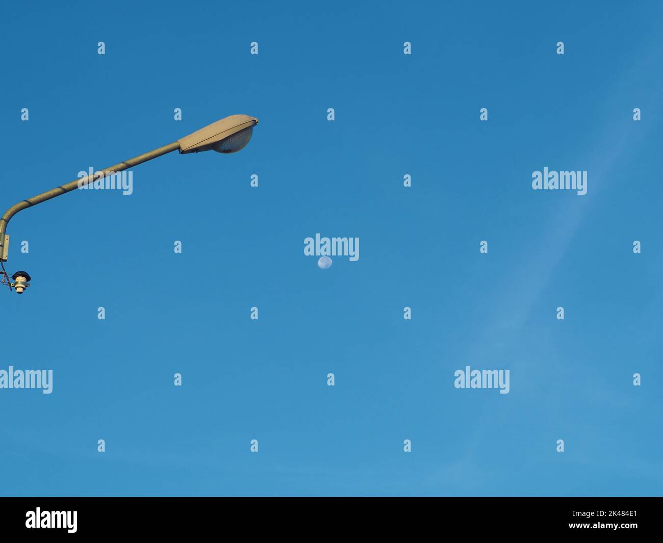 La torre della luce di strada sullo sfondo è cielo blu e c'è una piccola luna nel mezzo energia e concetti della natura. Immagine minima. Foto Stock