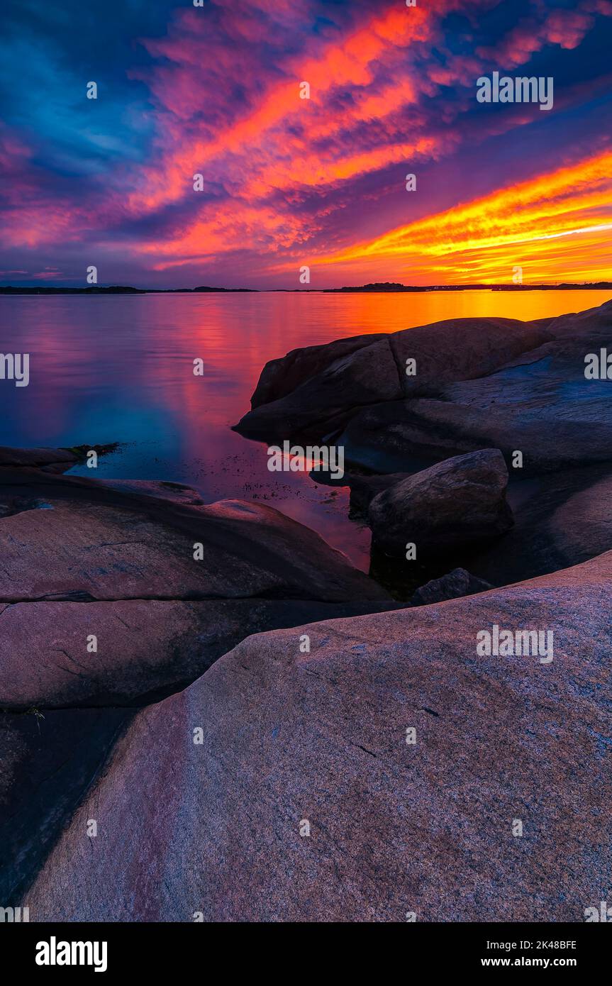 Una bella vista della costa rocciosa al tramonto con un cielo colorato Foto Stock