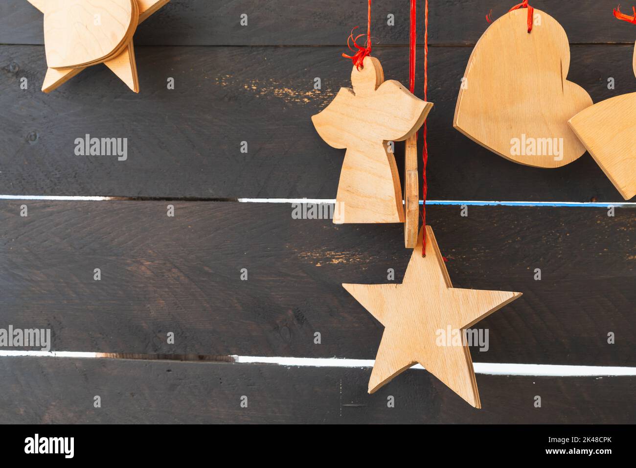 Le forme di legno, la decorazione di Natale appendono alla parete marrone scuro Foto Stock