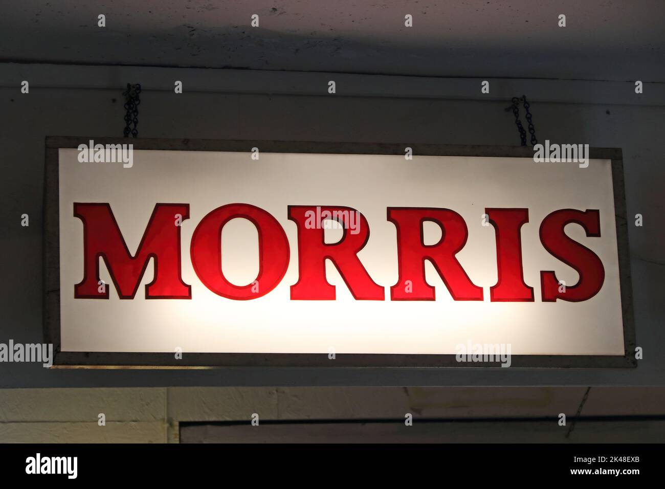 Vecchio, illuminato Morris segno pubblicitario utilizzato in garage di vendita auto Foto Stock