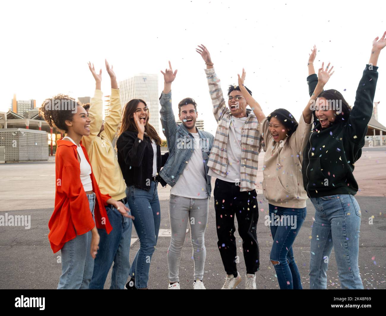 Gruppo di amici millenari multietnici che si divertano a fare festa e a lanciare i confetti. Amici che si divertono Foto Stock