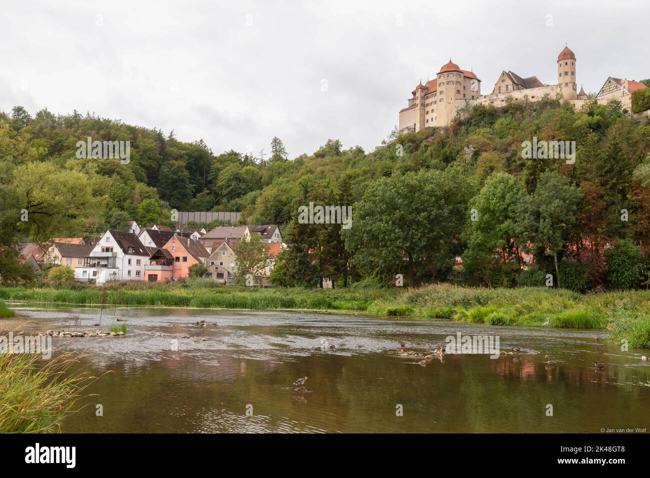 Il fiume Wörnitz si affaccia sul castello medievale di Harburg, nella pittoresca cittadina bavarese di Harburg, in Germania. Foto Stock