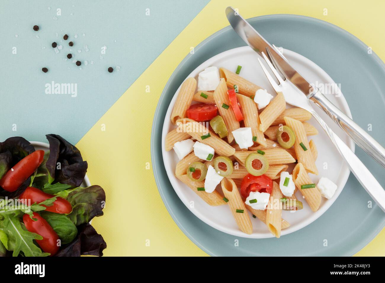 Insalata di penne di lenticchie rosse su sfondo a due colori Foto Stock