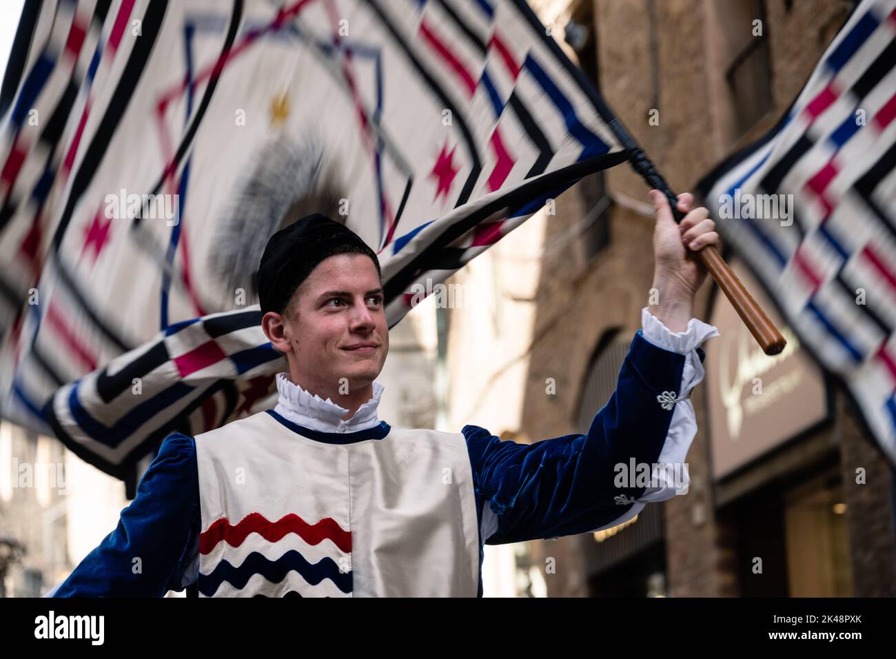 Siena, Toscana, Italia - Agosto 14 2022: Portatore di bandiera con la Bandiera o Standard dell'Istrice o Crested Procopine Contrada al Corteo storico Pag Foto Stock