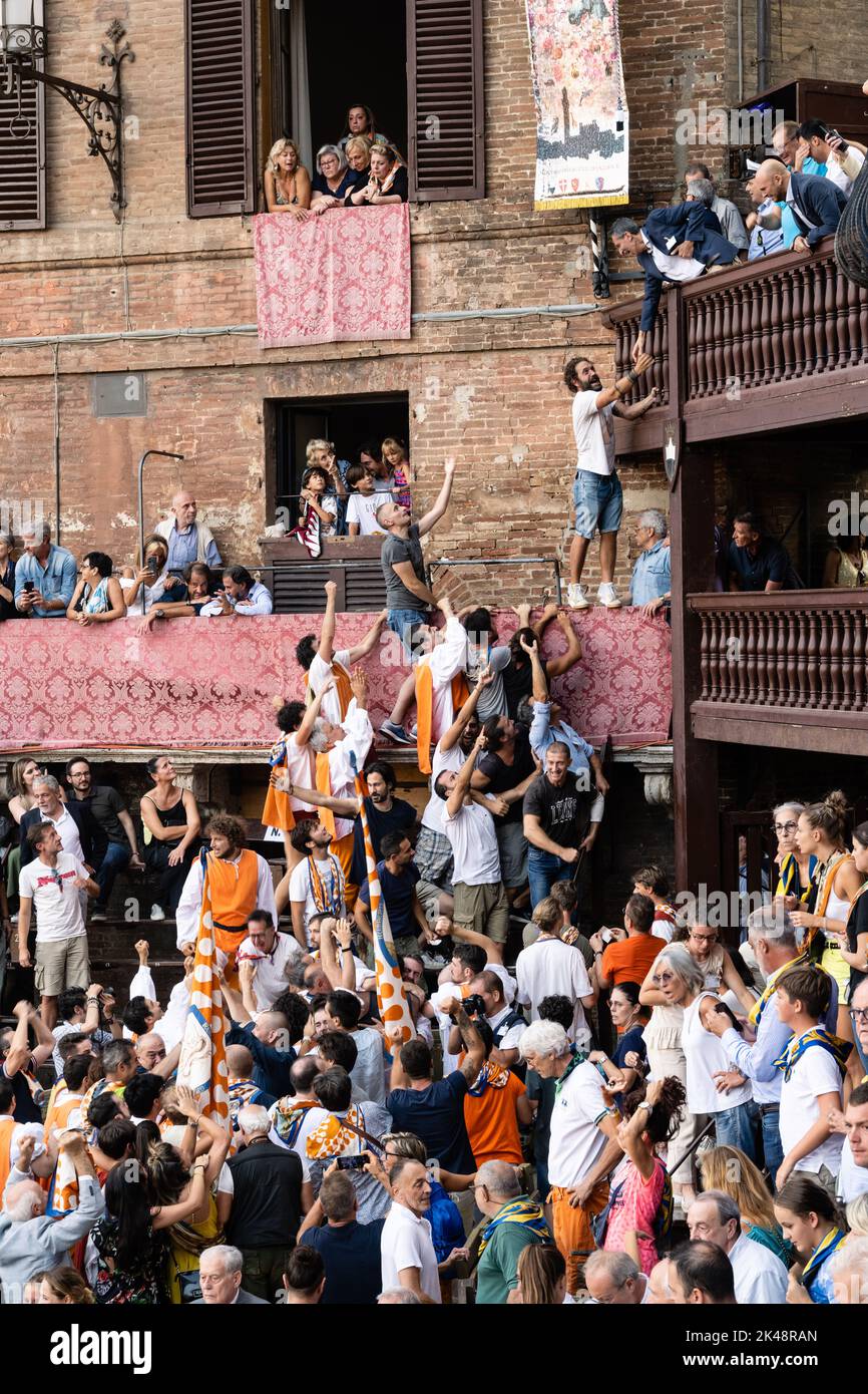Siena, Toscana, Italia - 17 2022 agosto: Festa della Vittoria del Palio con i membri del Leocorno Contrada che ricevono il Banner del Trofeo Drappellone. Foto Stock