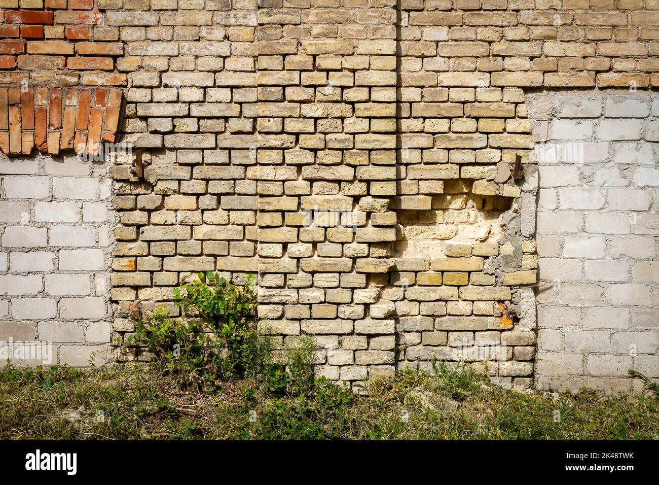 Il vecchio muro abbandonati con murate di windows. Architettura dettaglio dello sfondo. Edificio dimenticato di intonaco e mattoni rossi Foto Stock