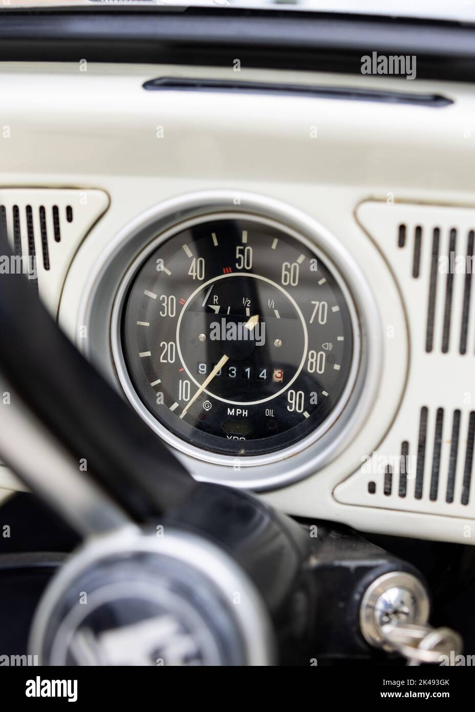 Auto d'epoca classica bianca retrò primo piano del tachimetro con un'elevata milage cronometrata con chiave inserita nell'accensione. Foto Stock