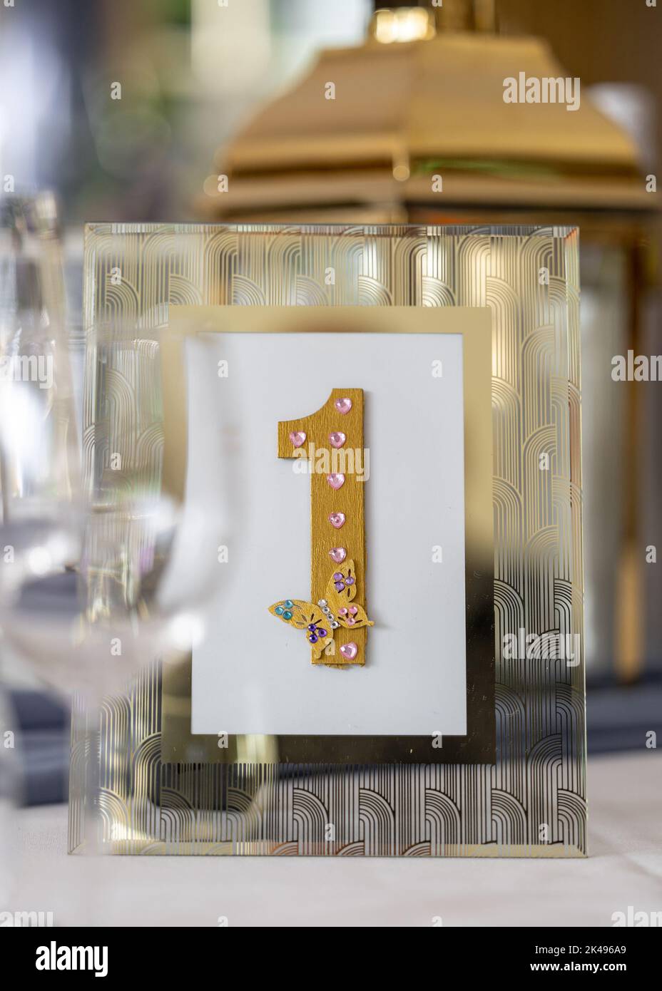 Tabella numero uno tavolo top card che mostra il numero 1 in oro per la celebrazione di nozze. Foto Stock