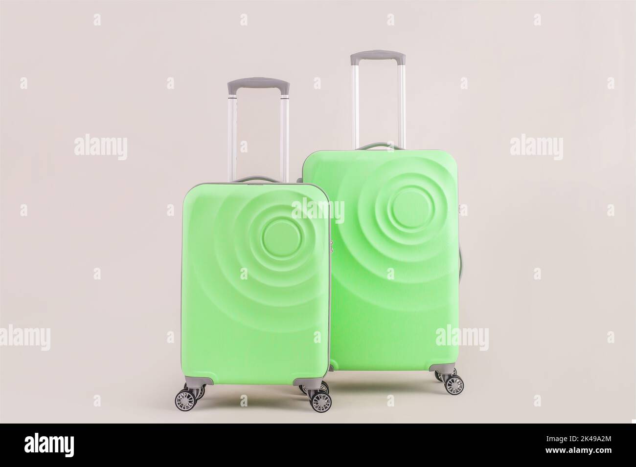 Valigia verde isolata su sfondo pastello bagaglio da vacanza Foto Stock