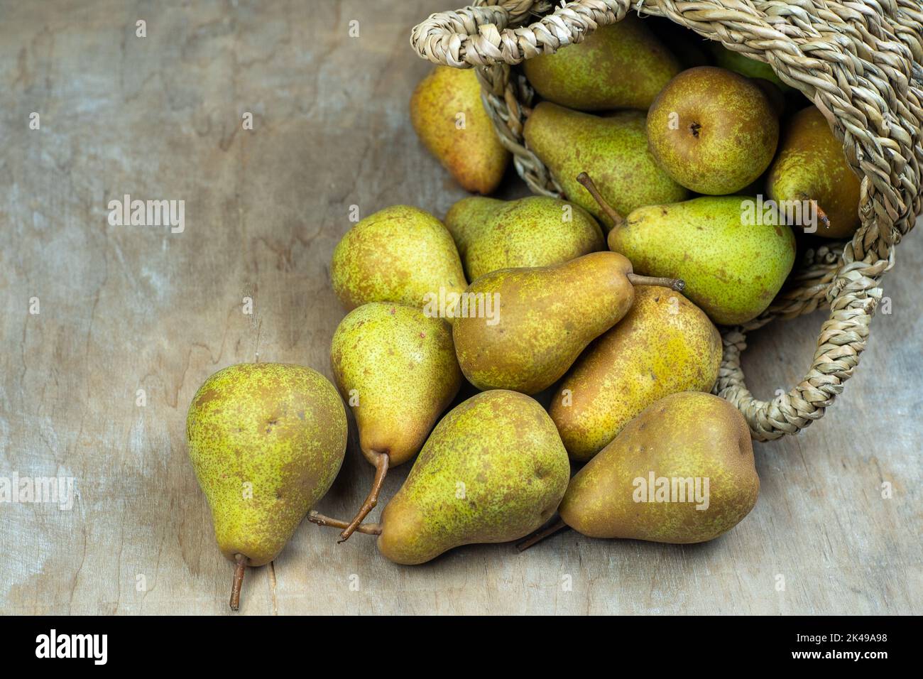 Pere in cesto su uno sfondo di legno. Raccolta di frutta. Autunno ancora vita. Pear Variety Bera Conference. Cibo vitaminico. Foto Stock