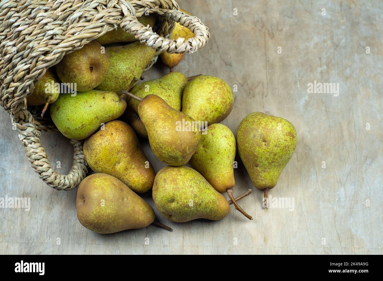 Pere in cesto su uno sfondo di legno. Raccolta di frutta. Autunno ancora vita. Pear Variety Bera Conference. Cibo vitaminico. Foto Stock