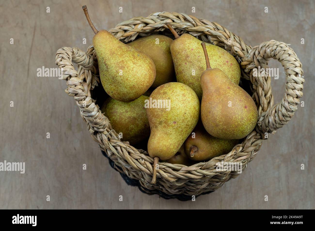 Pere in cesto su uno sfondo di legno. Raccolta di frutta. Autunno ancora vita. Pear Variety Bera Conference. Cibo vitaminico. Foto Stock