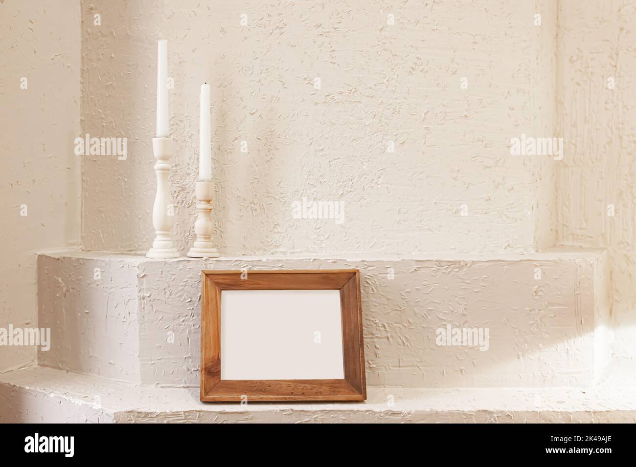 Fotografia del mockup orizzontale della struttura di legno e delle candele sullo sfondo bianco della parete dell'intonaco Foto Stock