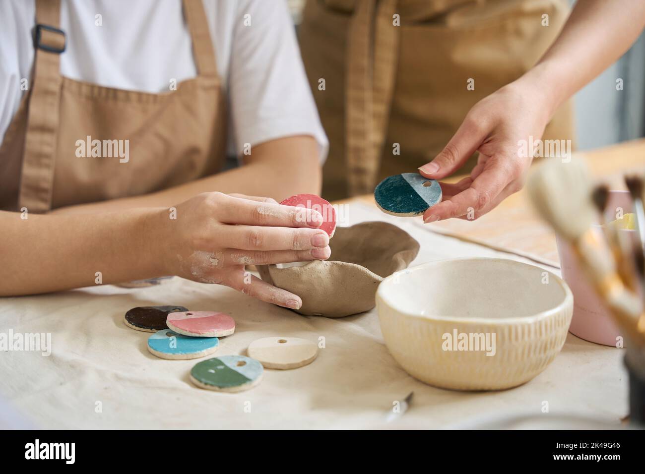 Le donne tengono campioni di vernice per prodotti di argilla nelle loro mani Foto Stock