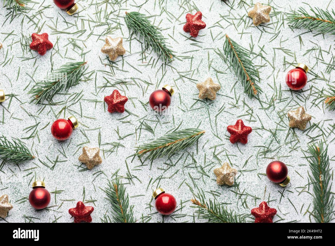 Sfondo natalizio creativo con palle di Natale, ramoscelli di pino, stelle rosse e dorate su sfondo bianco. Disposizione piatta, vista dall'alto, spazio di copia Foto Stock