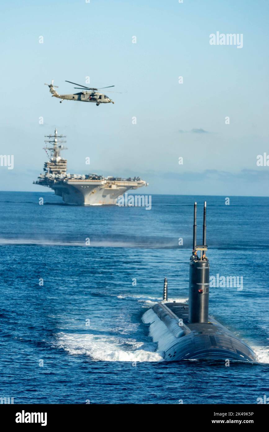 Busan, Corea del Sud. 30th Set, 2022. Un falco marino MH-60s della marina statunitense attaccato ai falchi dorati dello Squadrone 12 di combattimento marino dell'elicottero, si affaccia su una formazione del superportatore di classe Nimitz, alimentato da energia nucleare, La USS Ronald Reagan, guidata da un sottomarino ad attacco rapido di classe Los Angeles con il Submarine Group Seven, durante le operazioni di addestramento congiunte con la Marina sudcoreana nel Mar Orientale, il 30 settembre 2022 vicino a Busan, Corea del Sud. Credit: MC3 Gray Gibson/US Navy Photo/Alamy Live News Foto Stock