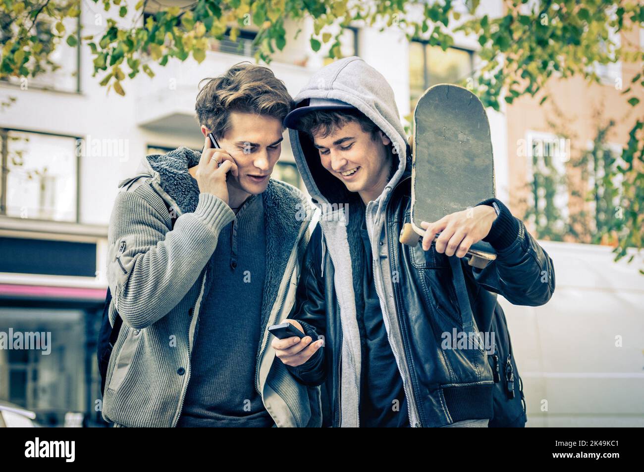 Giovani fratelli hipster divertirsi con lo smartphone - i migliori amici condividere il tempo libero con le nuove tecnologie di tendenza - ragazzi godersi i momenti della vita di tutti i giorni te Foto Stock