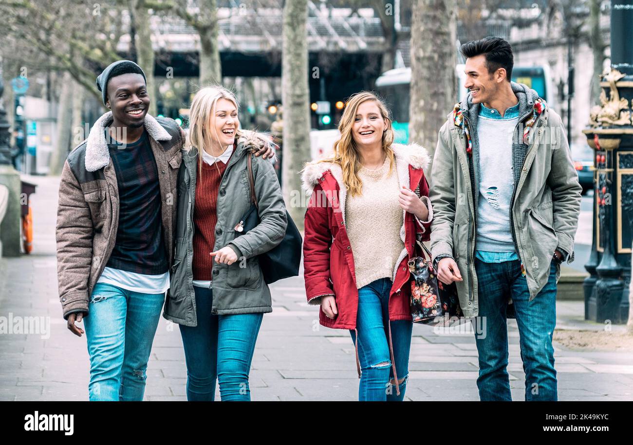 Gruppo multirazziale di amici milleniali che camminano nel centro di Londra - concetto di amicizia di prossima generazione su giovani multiculturali in inverno Foto Stock