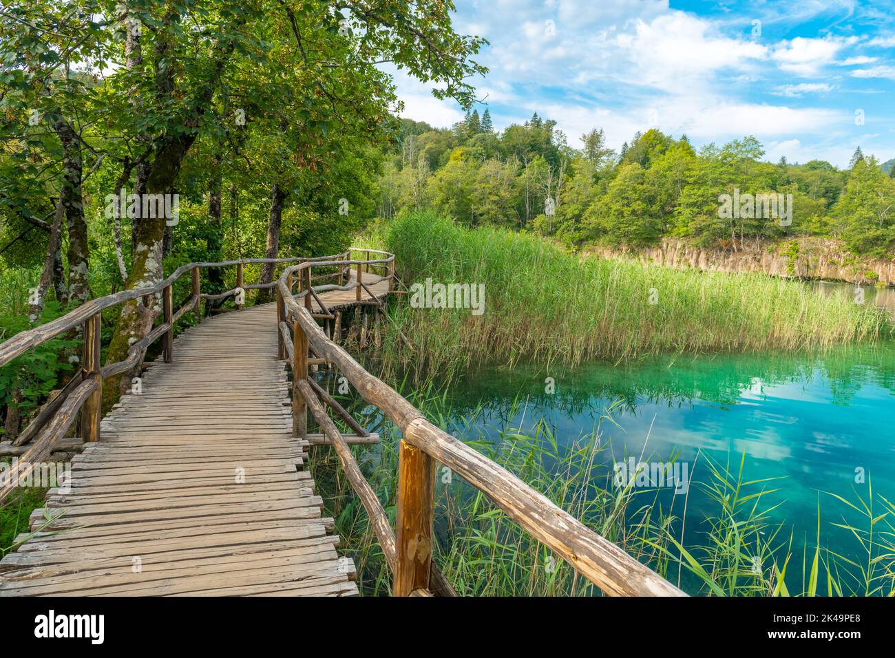 Una cava di legno conduce attraverso un lago nel Parco Nazionale dei Laghi di Plitvice. Foto Stock