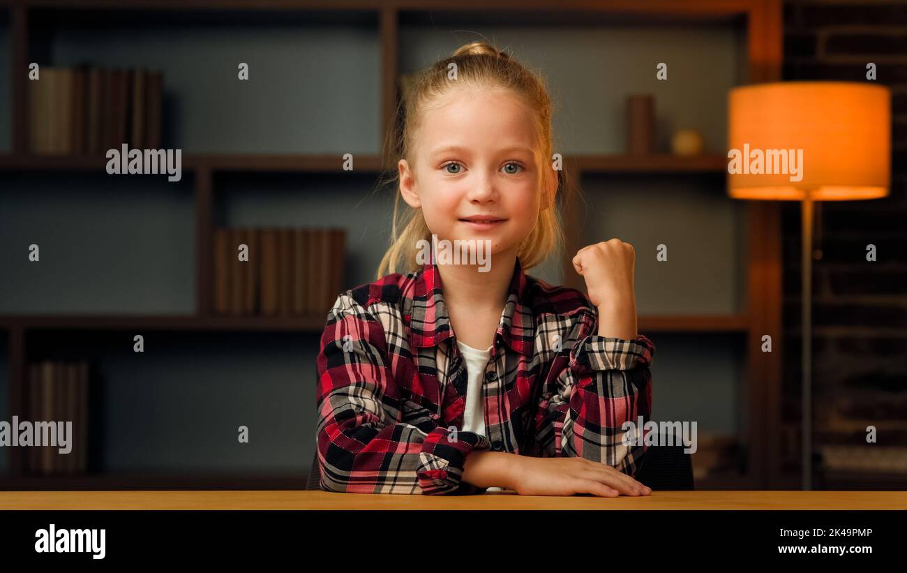 Overjoyed piccolo pupilla giovane bello in camicia che posa clenching facendo sì il gesto della mano. La ragazza vince la concorrenza raggiunge l'obiettivo rende trionfo simbolo Foto Stock