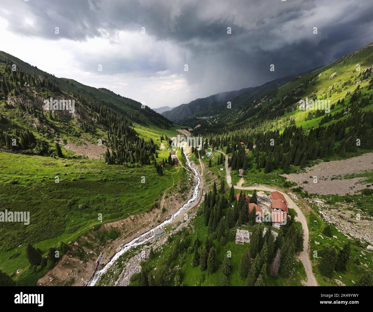 Splendido scenario delle montagne con verde collina e fiume in tempesta pioggia cielo nuvoloso e resort in Almaty, Kazakistan. Esterno e concetto di escursioni Foto Stock